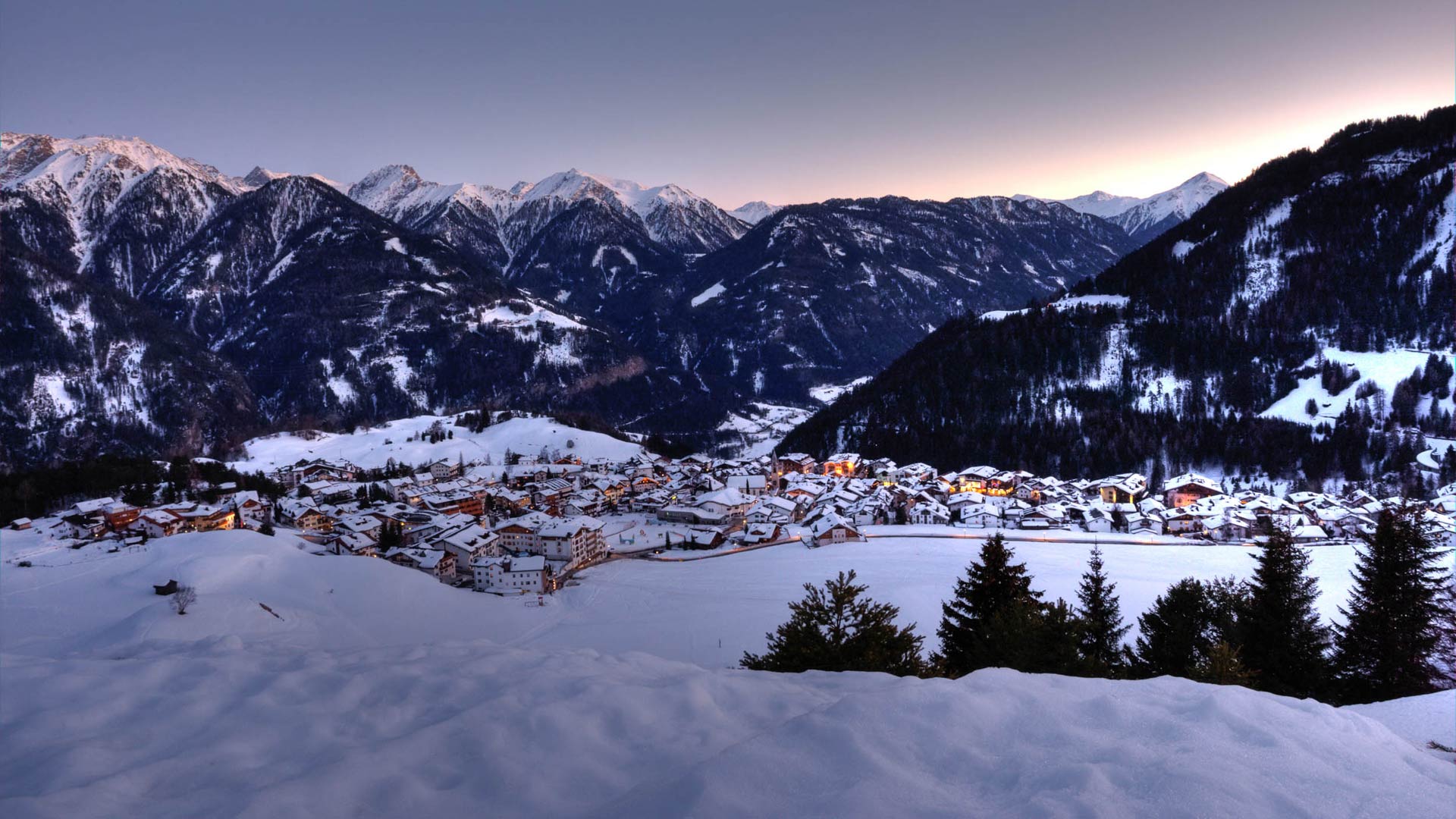 Serfaus in der Dämmerung – warmes Lichtermeer trifft auf verschneite Stille. Winterzauber pur in den Alpen.
